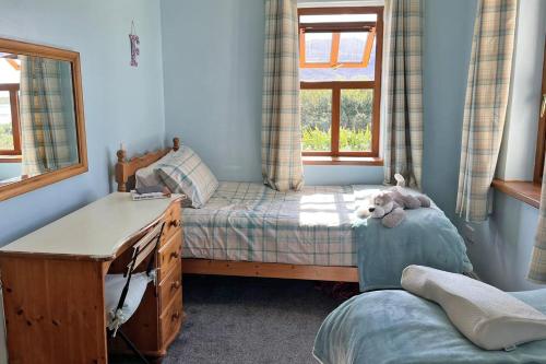 a bedroom with a bed and a desk and a window at Achill Sound Holiday Village No 11 in Achill Sound