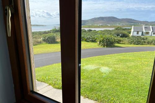 a window with a view of a road and grass at Achill Sound Holiday Village No 11 by Trident Holiday Homes in Achill Sound