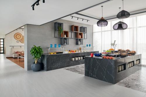 a kitchen with a counter with food on it at Movenpick Jumeirah Village Triangle in Dubai