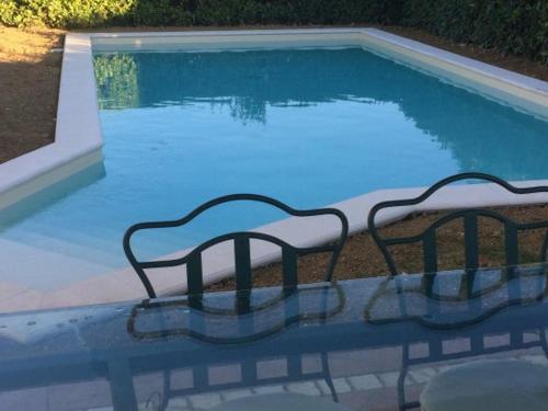 a swimming pool with two chairs in front of it at Nonna Anita Palace Narni in Narni