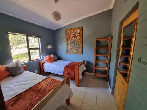 a bedroom with two beds and a ladder in it at Abaloo Apartment #1 in Sabie