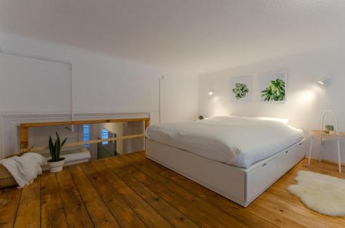 1 dormitorio con 1 cama blanca grande y suelo de madera en COSY APARTMENT IN CENTRAL DISTRICT., en Budapest