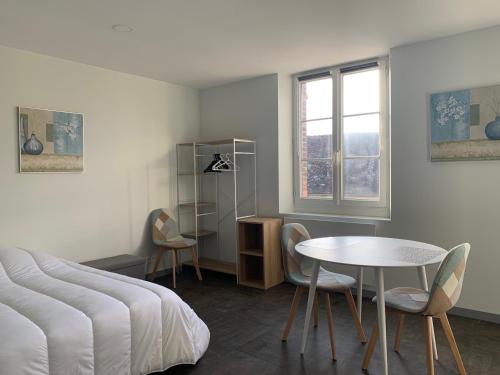 um quarto com uma cama, uma mesa e cadeiras em Studio Soligny em Soligny-les-Étangs