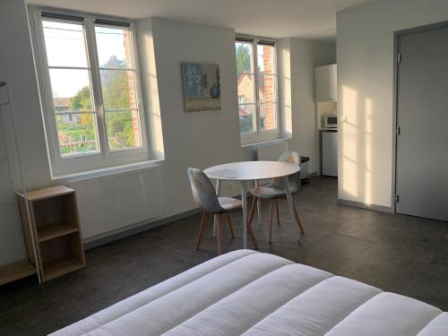 a room with a bed and a table and chairs at Studio Soligny in Soligny-les-Étangs
