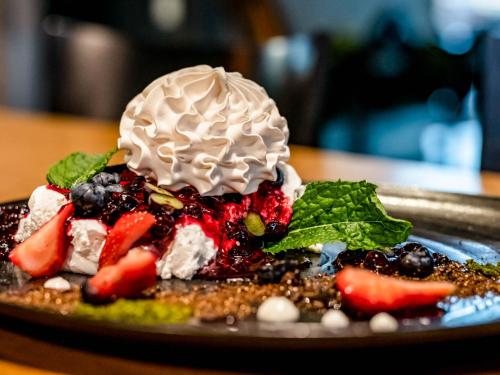 a dessert with fruit and ice cream on a plate at Salio Equisport Resort in Stryków