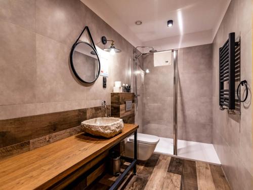 a bathroom with a sink and a toilet and a mirror at Salio Equisport Resort in Stryków