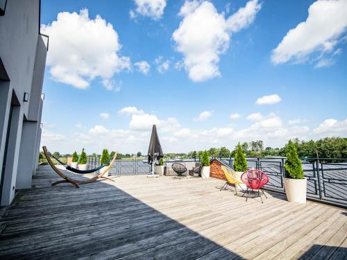 a deck with chairs and hammocks on top of a building at Salio Equisport Resort in Stryków