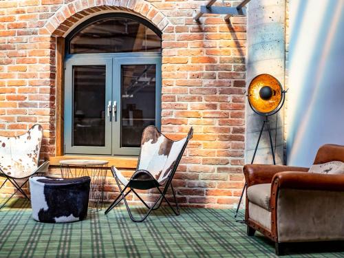 a room with chairs and a brick wall at Salio Equisport Resort in Stryków