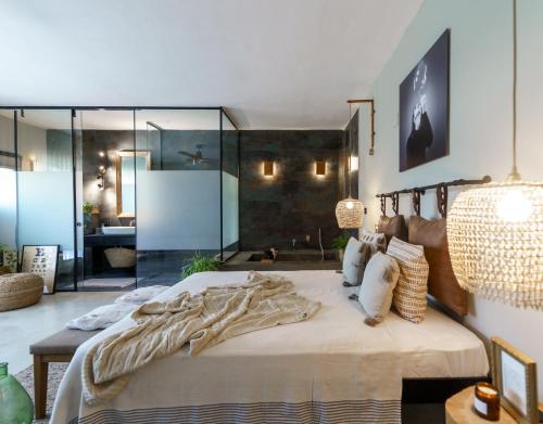 1 dormitorio con 1 cama grande y pared de cristal en גלילה - סוויטת בוטיק רומנטיות לזוגות עם האט טאב פרטי ליד הים en Bustan HaGalil
