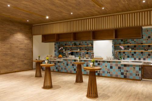 a restaurant with four stools in the middle of a room at Fusion Suites Vung Tau in Vung Tau