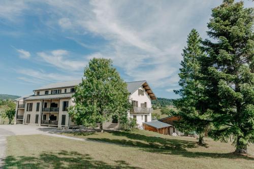 a large white house with two trees in front of it at R&eacute;sidence Les Clarines ( by Popinns ) in Les Rousses