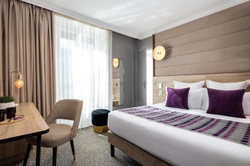 パリにあるHôtel Nude Paris - Color Visionの大きなベッドとデスクが備わるホテルルームです。
