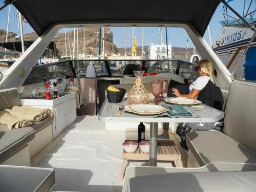 a woman sitting at a table on a yacht at Boat in Puerto de Mogán in Puerto de Mogán