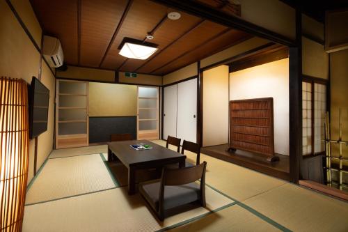 京都市にあるKanade Fushimiinariのテーブルと椅子、ドアが備わる部屋