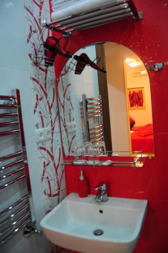 a red bathroom with a sink and a mirror at Azoyan Guest House in Yerevan