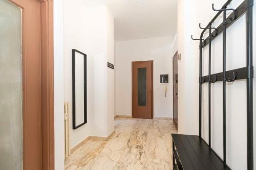 a hallway with white walls and marble floors and a door at Angeletti Home in Gassino Torinese