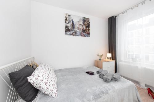 a white bedroom with a bed and a window at Project Comfort Apartament Potrzebna 55/130 Warszawa in Warsaw
