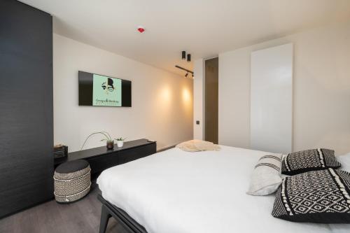 um quarto com uma cama branca e uma janela em Georges & Madeleine Apartments em Aalst