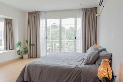 a bedroom with a bed and a large window at PB Place @ Kwan Payao in Phayao