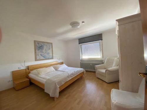 ノイシュタット・アン・デア・ヴァインシュトラーセにあるFerienwohnung Rebenmeerのベッドルーム1室(ベッド1台、ソファ、椅子付)