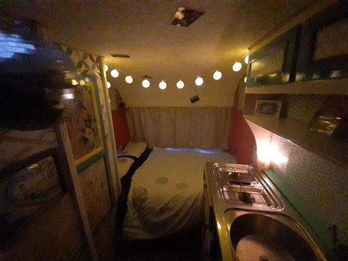 a small room with a bed with lights in it at Father Ted Retro Caravan! in Drumaville