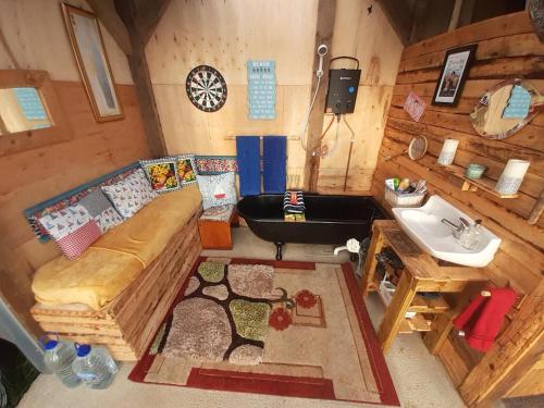 Zimmer mit Sofa und Waschbecken in einer Hütte in der Unterkunft Father Ted Retro Caravan! in Drumaville