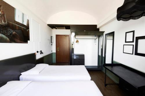 ein Schlafzimmer mit zwei Betten und einem Schreibtisch in der Unterkunft Generator Rome in Rom