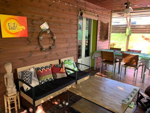 a screened in porch with a couch and a table at Le Dodo Salé in Étang-Salé