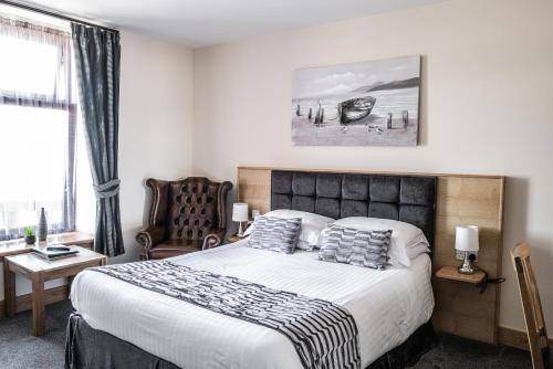 um quarto com uma cama grande e uma cadeira em Seaview Hotel em Peterhead