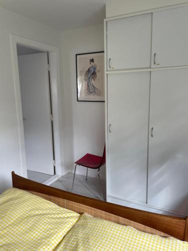 a bedroom with a mirror and a bed and a chair at Løkke-bo in Løkken