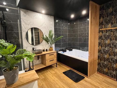 Suite cocooning & spa في بيزييه: حمام مع حوض ومغسلة ومرآة