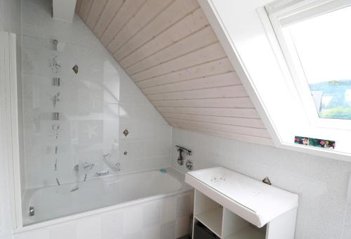 ein Bad mit einer weißen Badewanne und einem Fenster in der Unterkunft Ferienwohnung Schneelehner, 2-Schlafzimmer, Feldberg, in Feldberg