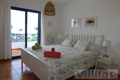een slaapkamer met een bed met een rode doos erop bij VILLA DUNIA by Villitas in Playa Blanca