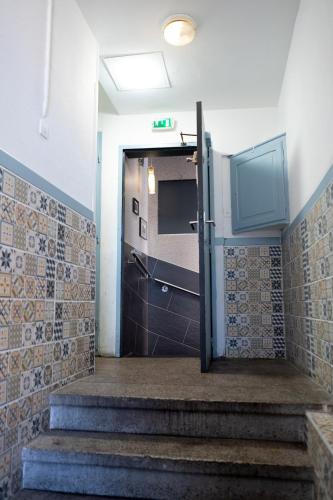 a hallway with stairs leading to a door with a television at SECRET MAMA with mobile aircon, including a free parking space at 200 meters in Colmar