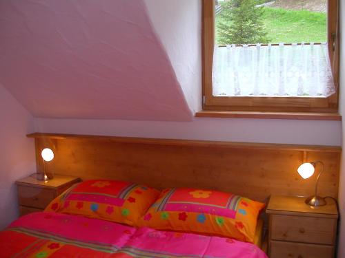 a bedroom with a bed with two lamps and a window at Appartement Luisa in Bad Kleinkirchheim