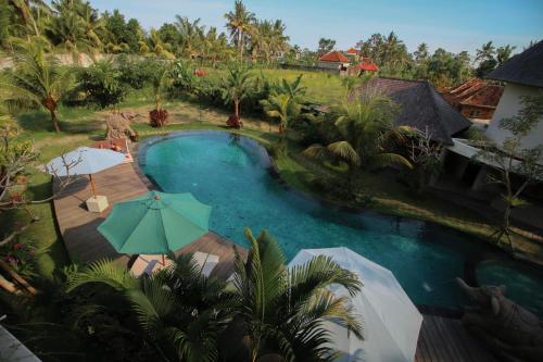 an aerial view of a swimming pool with umbrellas at Queen at Gunung Sari in Ubud