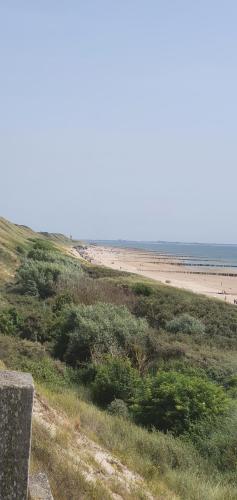 uma vista para uma praia com pessoas à distância em Mooi Chalet voor een Top Vakantie aan Zee em Biggekerke