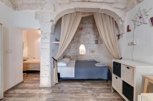 a bedroom with a bed in a stone wall at Casa Anmori in Ostuni