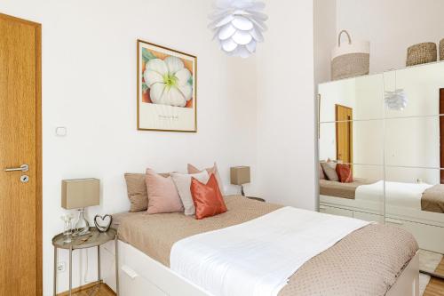 une chambre blanche avec un lit et un miroir dans l'établissement KAZ13 Kazinczy Apartment, à Budapest