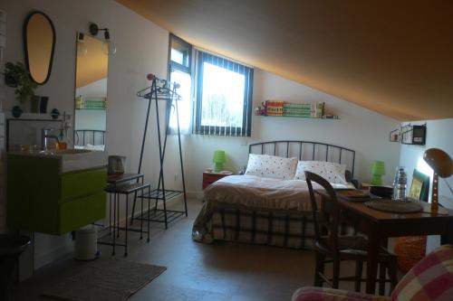 a bedroom with a bed and a desk and a window at les kiwis in Saint-Yrieix-sur-Charente