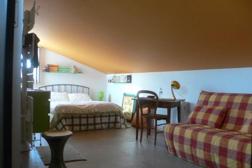 a bedroom with a bed and a desk and a chair at les kiwis in Saint-Yrieix-sur-Charente