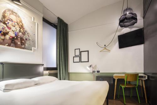 a bedroom with a bed and a desk with a television at Generator Rome in Rome