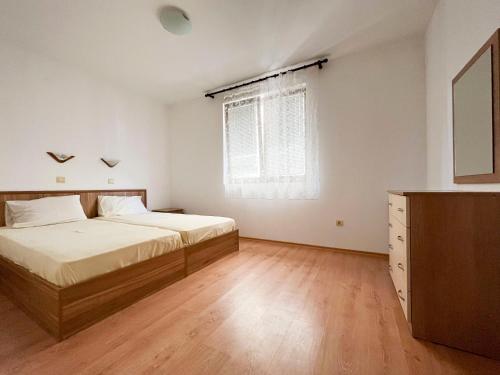 a bedroom with two beds and a dresser and a window at Комплекс «ТОП» in Sveti Vlas