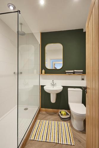 a bathroom with a toilet and a sink and a mirror at Kin Ludlow Rooms in Ludlow