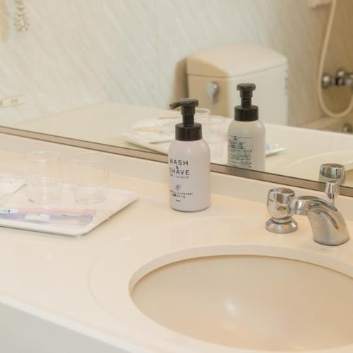 a bathroom sink with two lotion bottles on it at Onahama Ocean Hotel & Golf Club in Iwaki