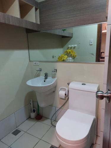 a bathroom with a white toilet and a sink at Jojie's Crib Horizons101 Studio II in Cebu City