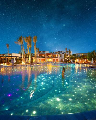 a person in a swimming pool at night at Port Royal Villas and Spa - Adults Only in Kolimbia