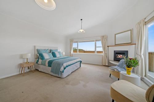 um quarto com uma cama e uma lareira em Kapiti Getaway - Paraparaumu Beach Rental em Paraparaumu Beach