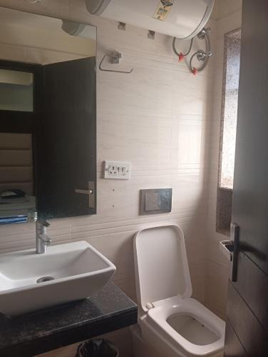a bathroom with a white toilet and a sink at Hotel Presidency Inn in Kolkata