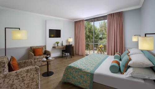 a hotel room with a bed and a living room at Nof Ginosar Kibbutz Hotel in Kibbutz Ginnosar